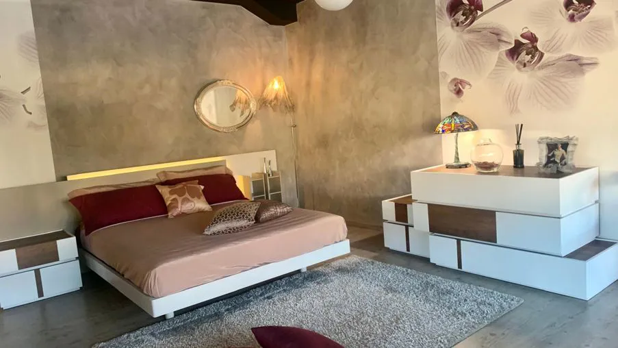 Camera da letto padronale tra geometrie asimmetriche e dettagli d'atmosfera